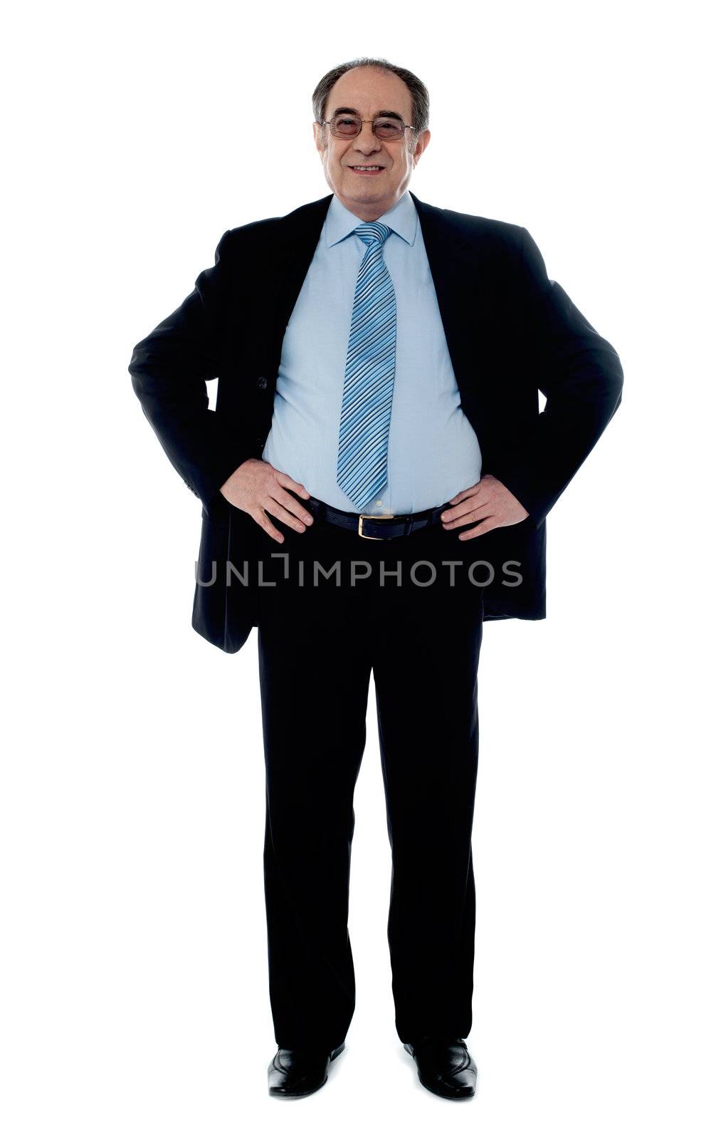Senior manager poisng with hands on his waist by stockyimages