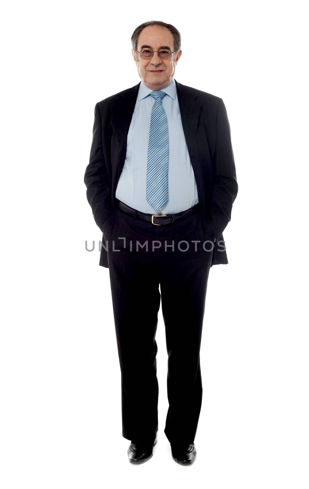 Company manager wearing black suit standing in front of camera with hands in pocket