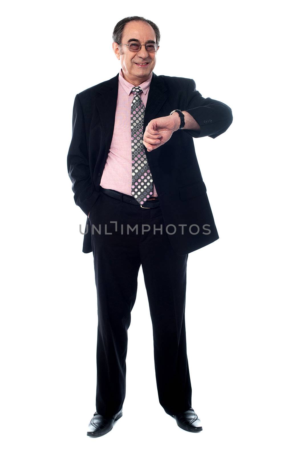 Senior businessperson smiling and taking a look at his watch