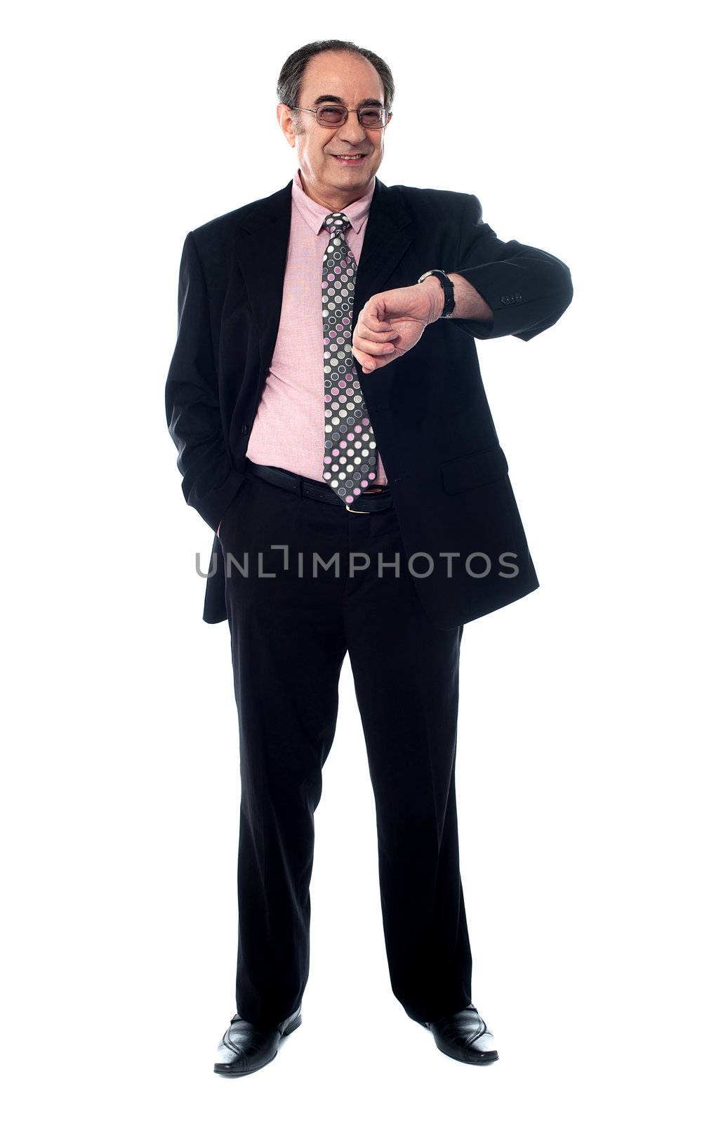 Senior businessperson smiling and taking a look at his watch