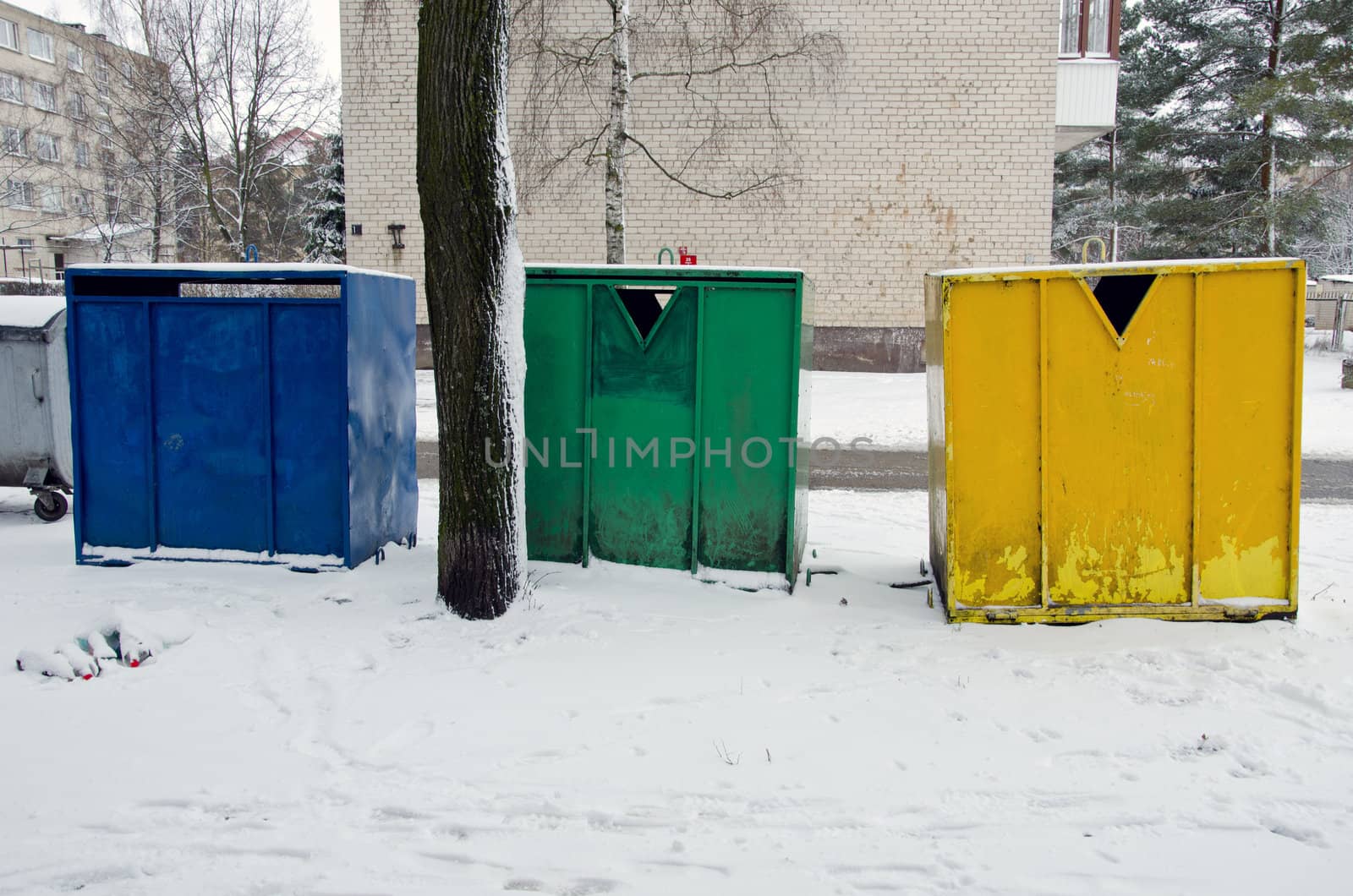 waste sorting in multistore residential houses district. colorful metal garbage containers area in city.