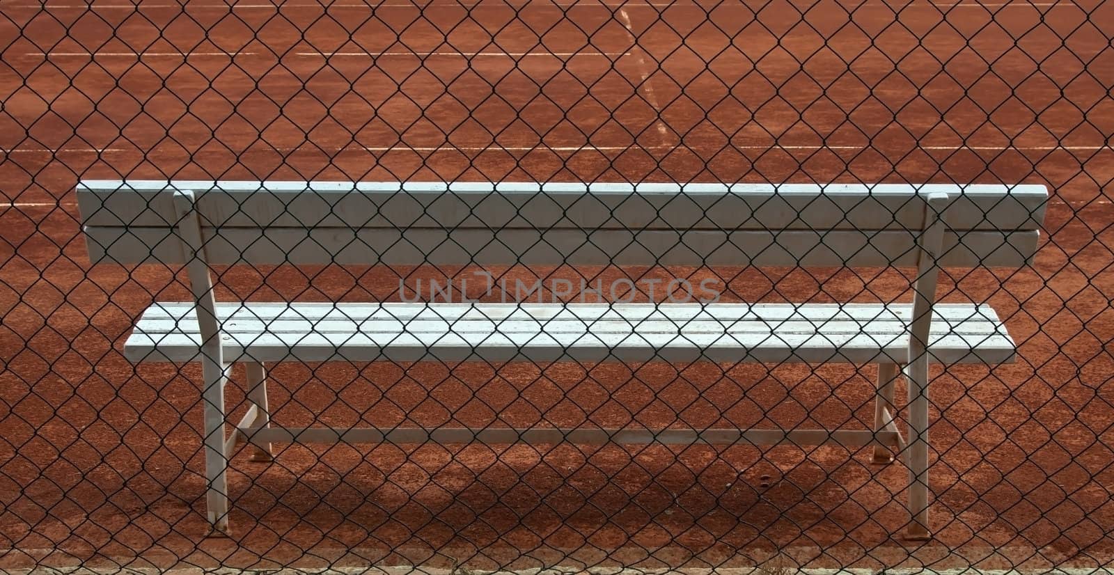 empty tennis court  and white wooden seat