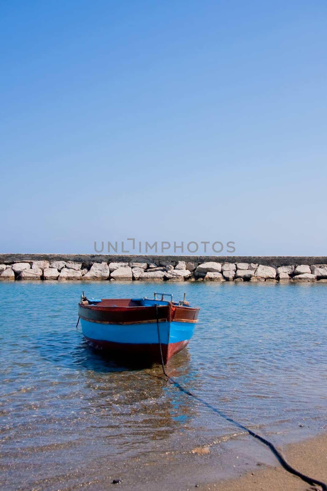 Small fishing boat floating on the water, in Ischia Italy