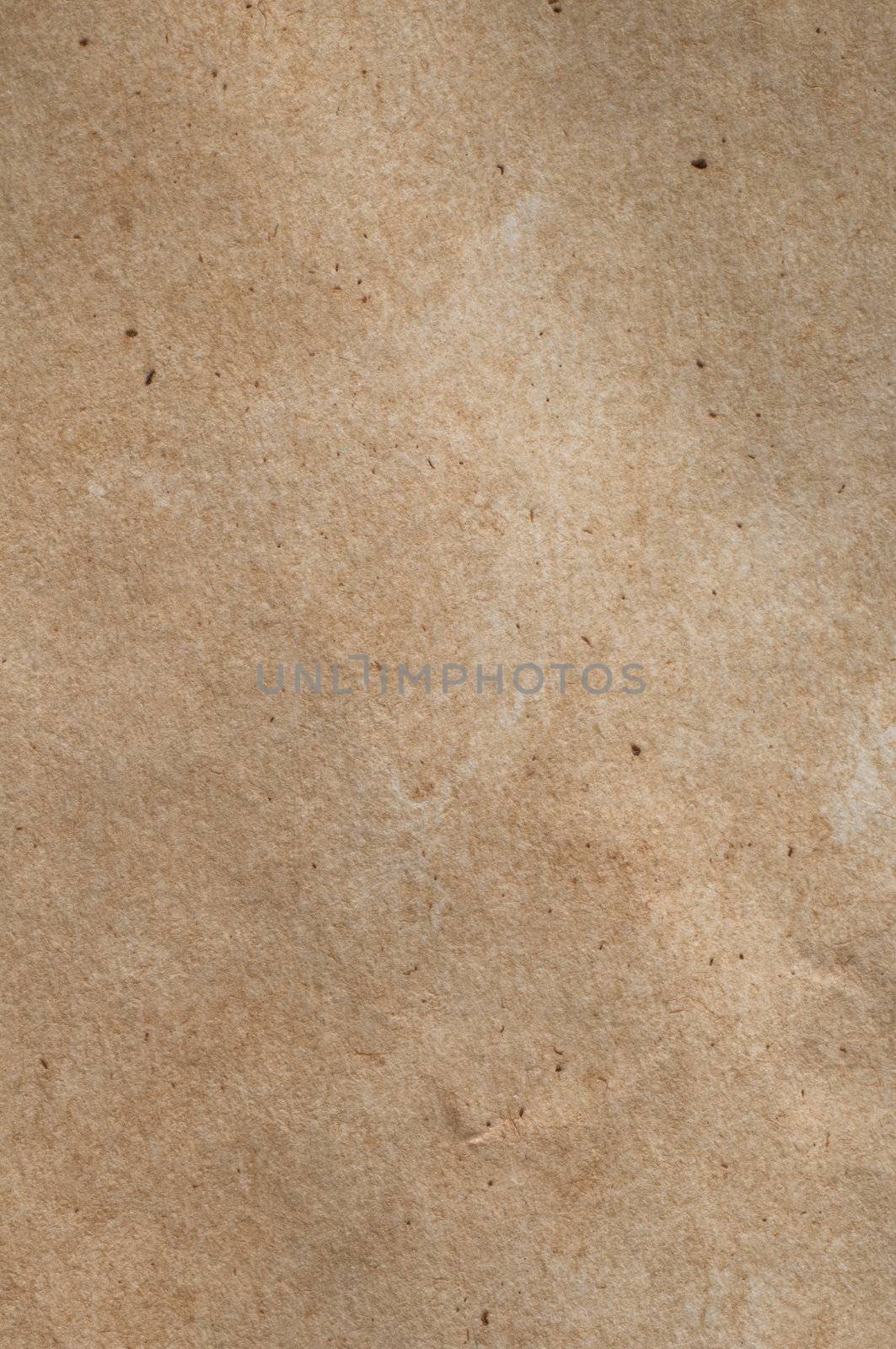 A piece of mid-toned fibrous, textured brown paper with scratches, fibres and flecks visible.