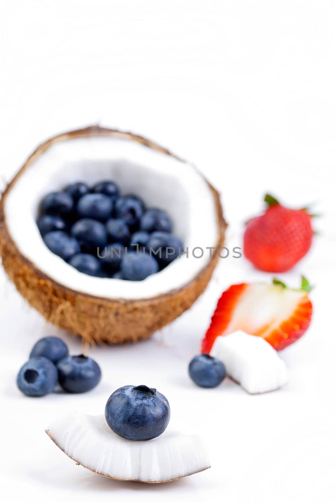 healthy fresh fruits - strawberry, blueberry and coconut isolated on white background