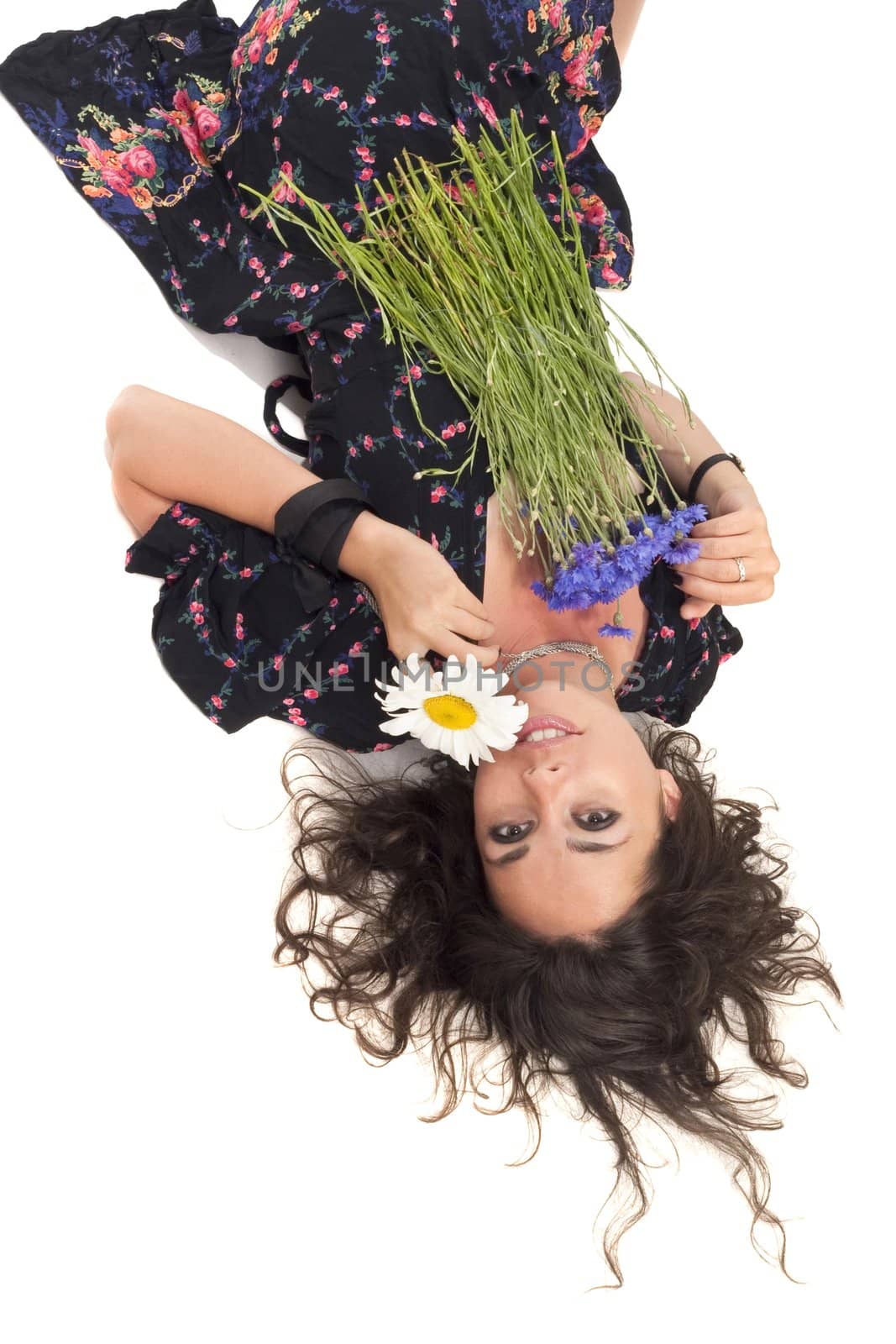 Young girl laying on a flour with bunch of flowers