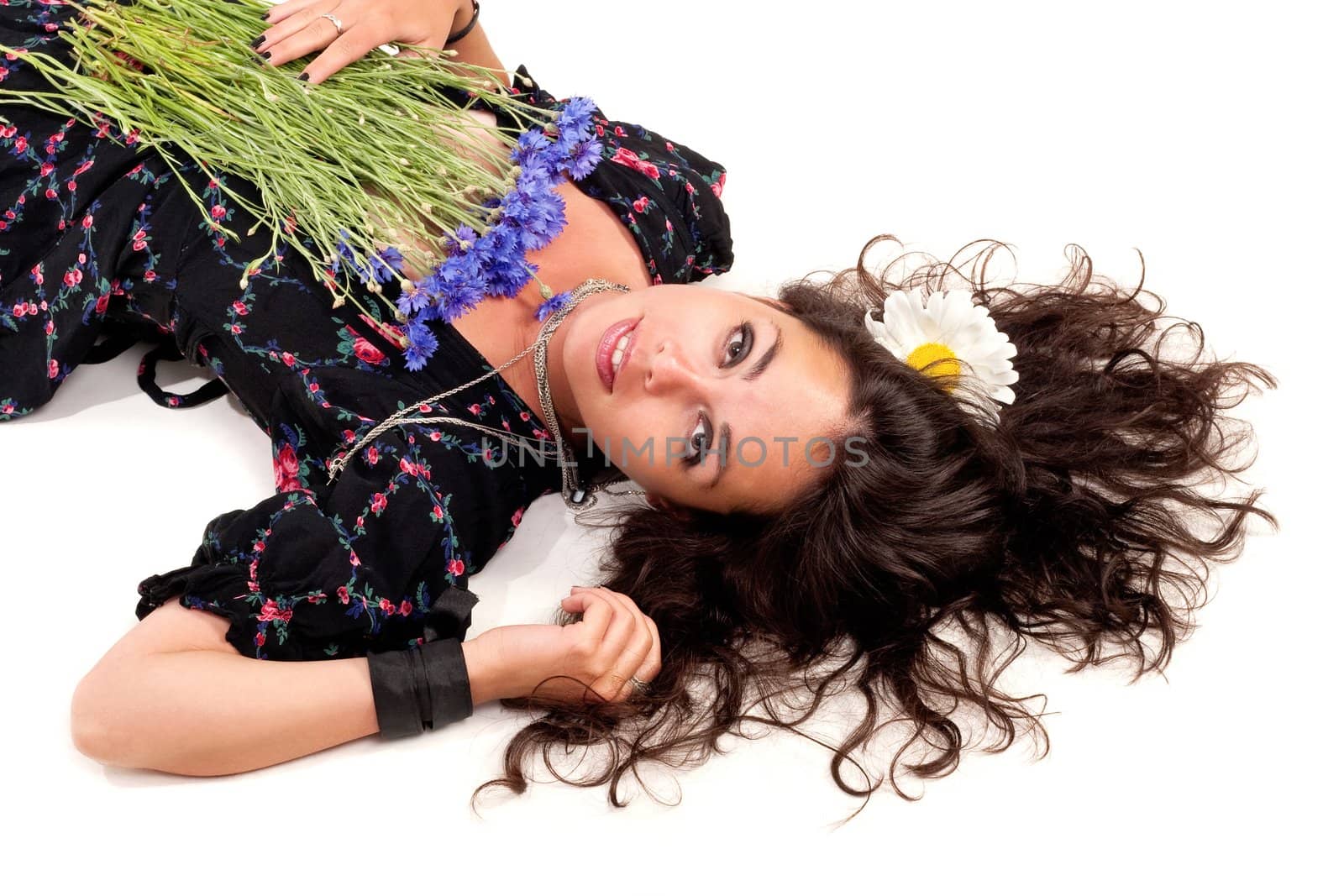 Young girl laying on a flour with bunch of flowers