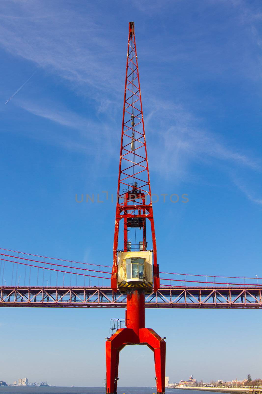 red crane and red metallic bridge in port