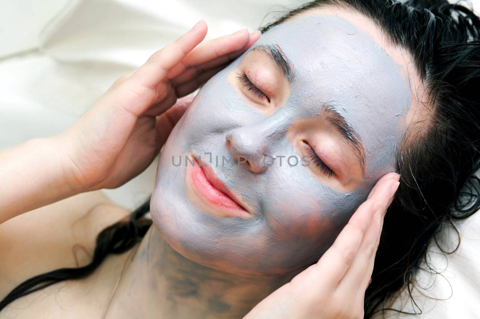 A woman putting a  mask on her face