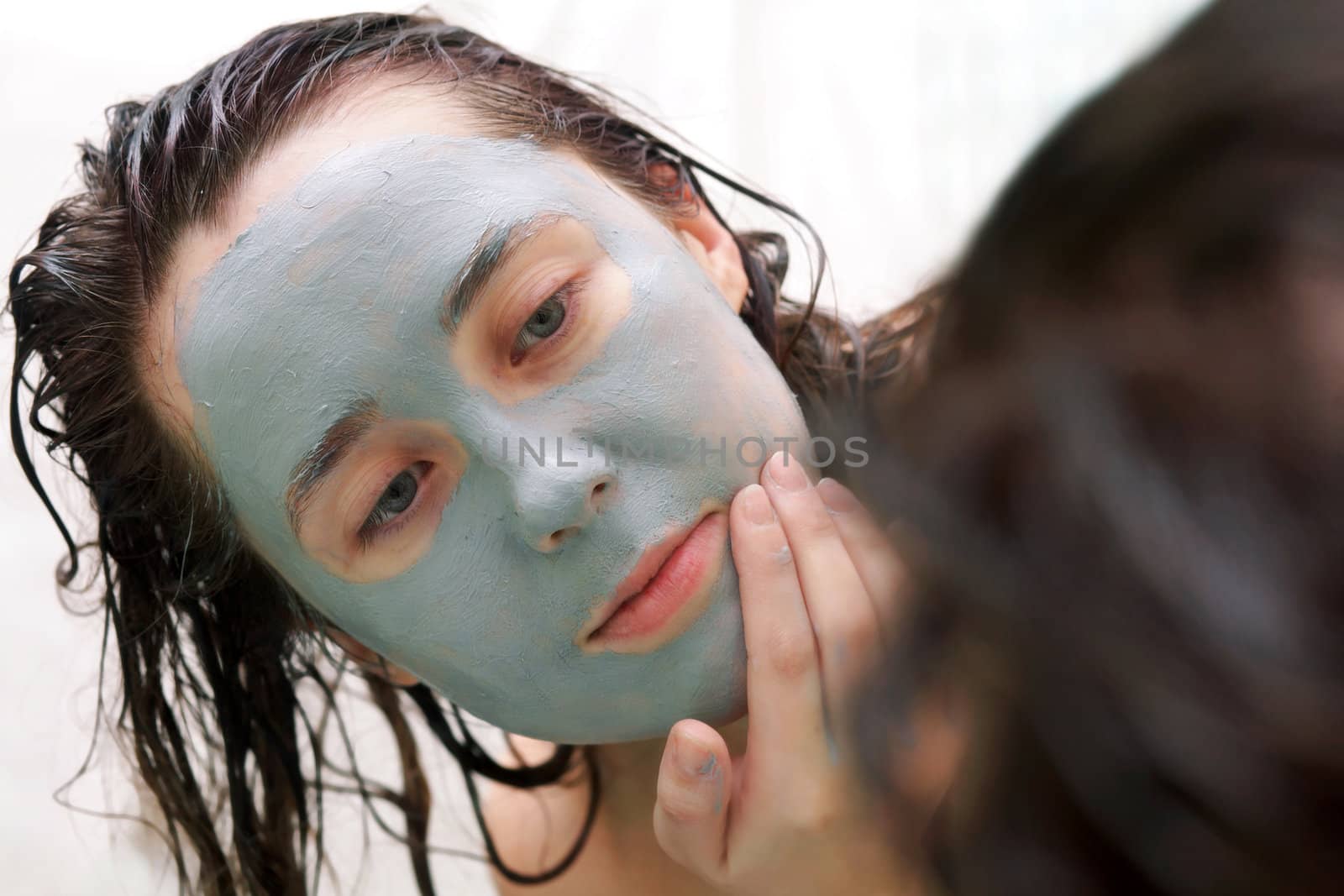 Woman putting a mud mask by velkol