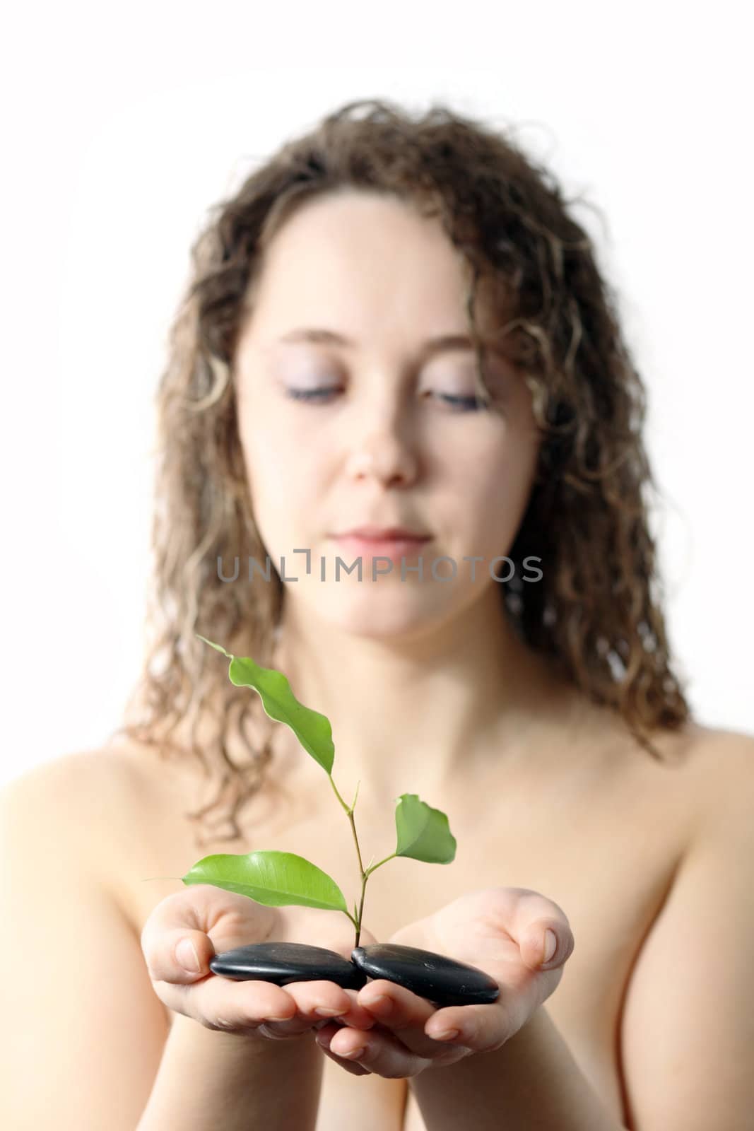 Stock photo: an image of a girl with plant and stones in her hands