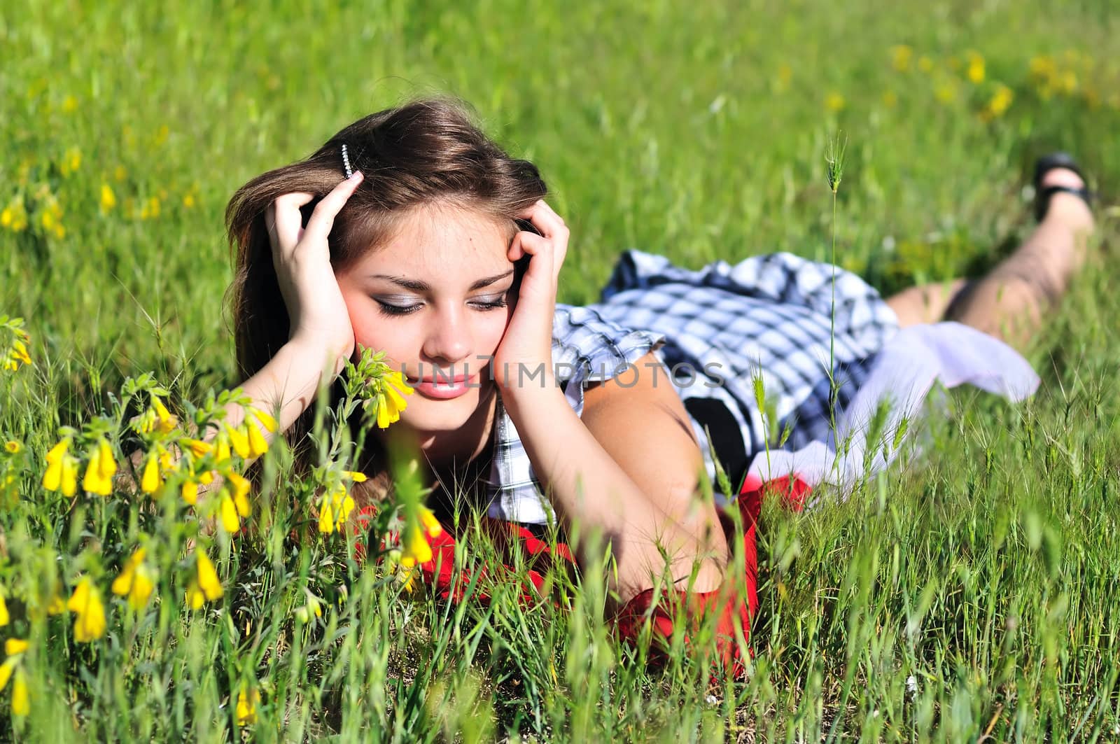 beautiful teen girl laying on the spring meadow 
