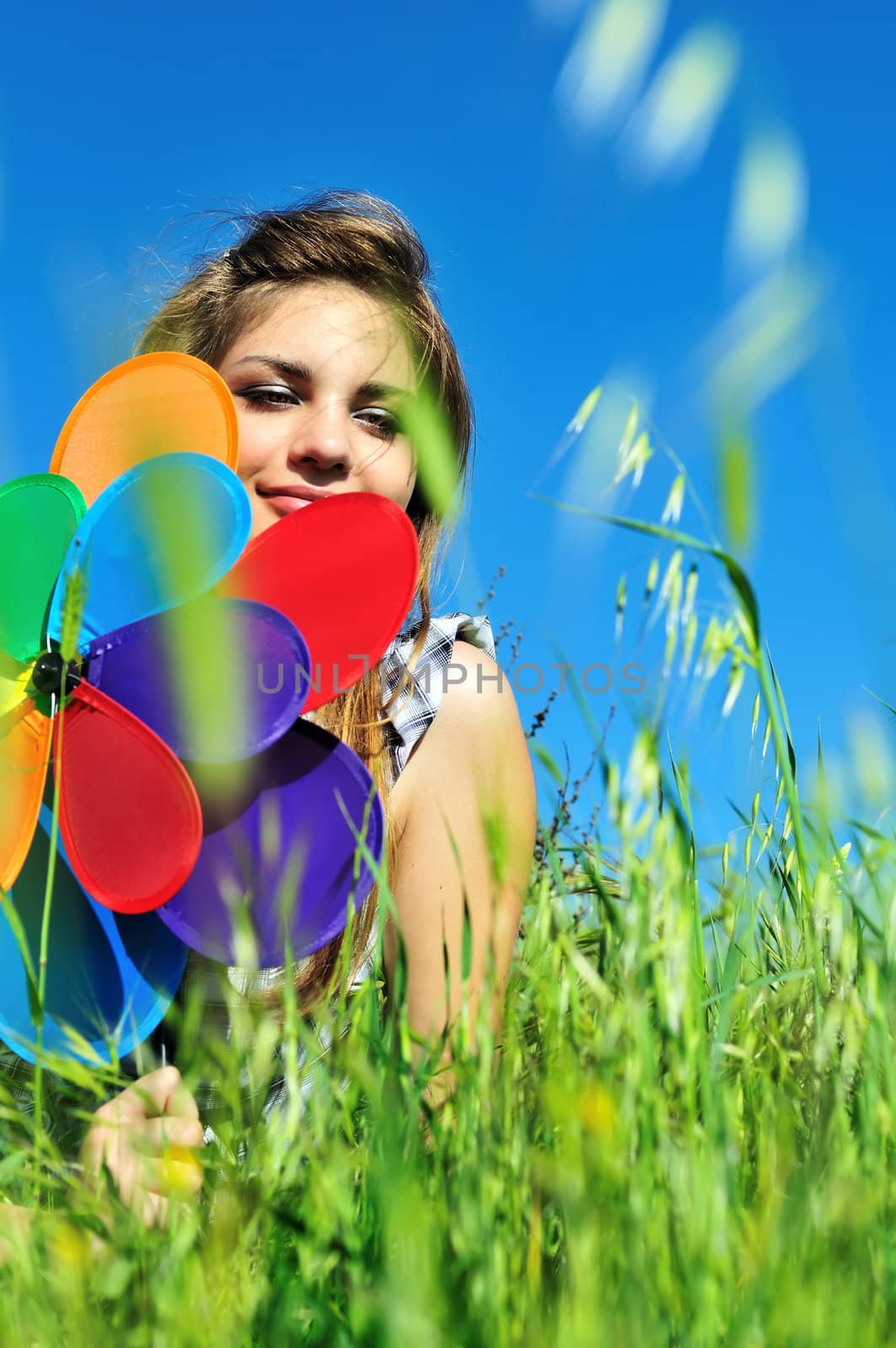 girl with windmill sitting in the grass