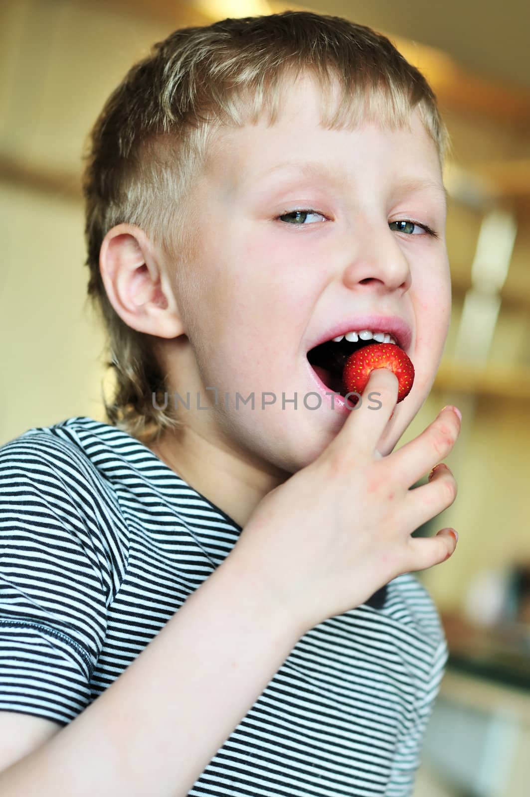 little funny boy is enjoying strawberry