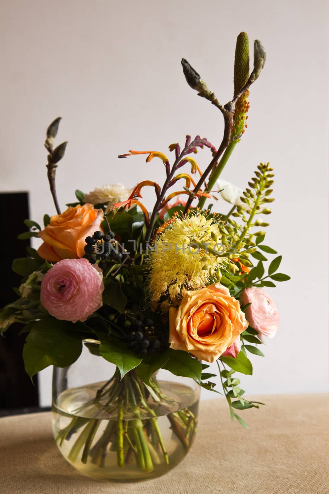 Bouquet of flowers in glass vase with modern fireplace in background