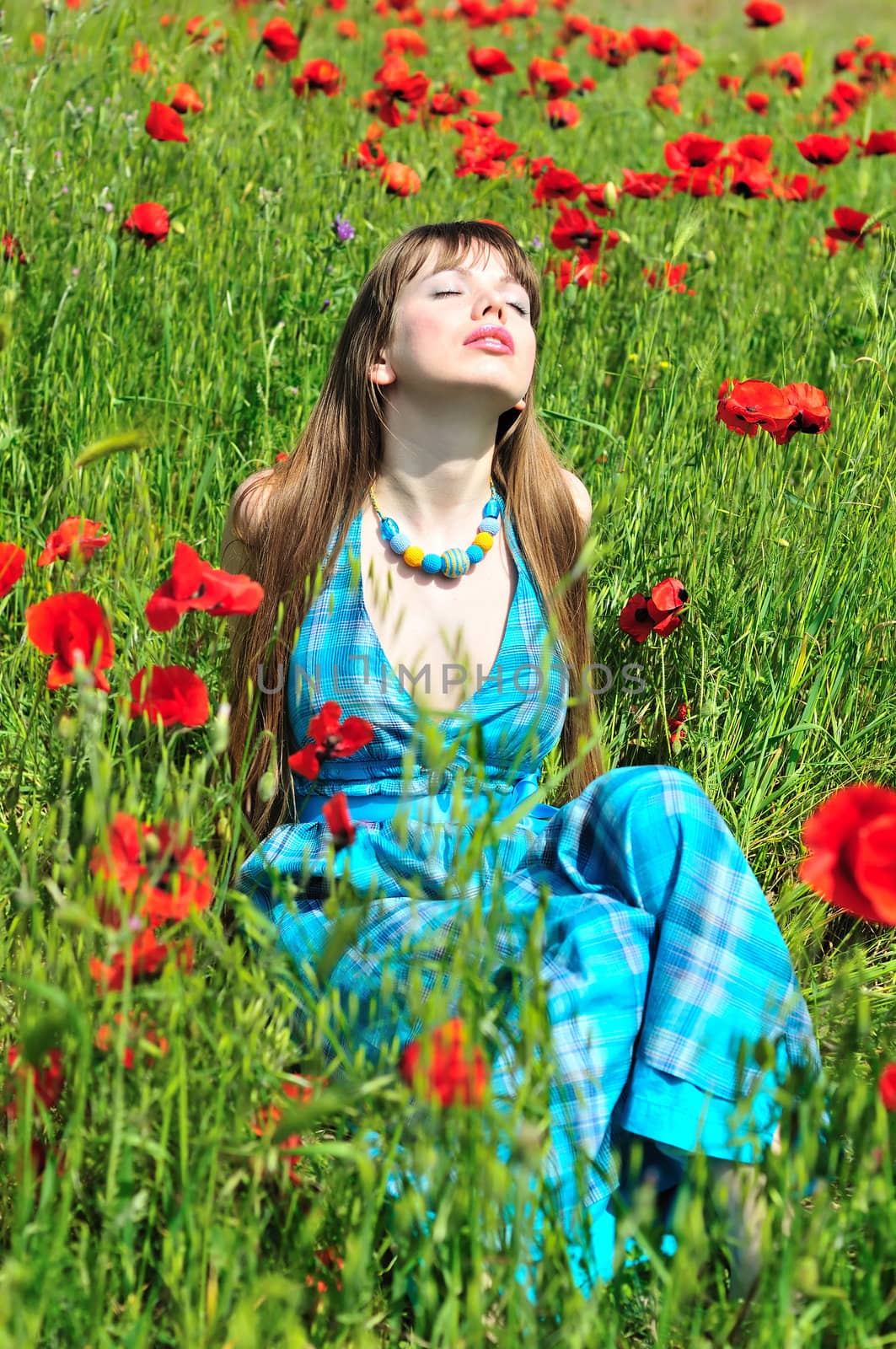 longhaired young woman relaxing in poppy field