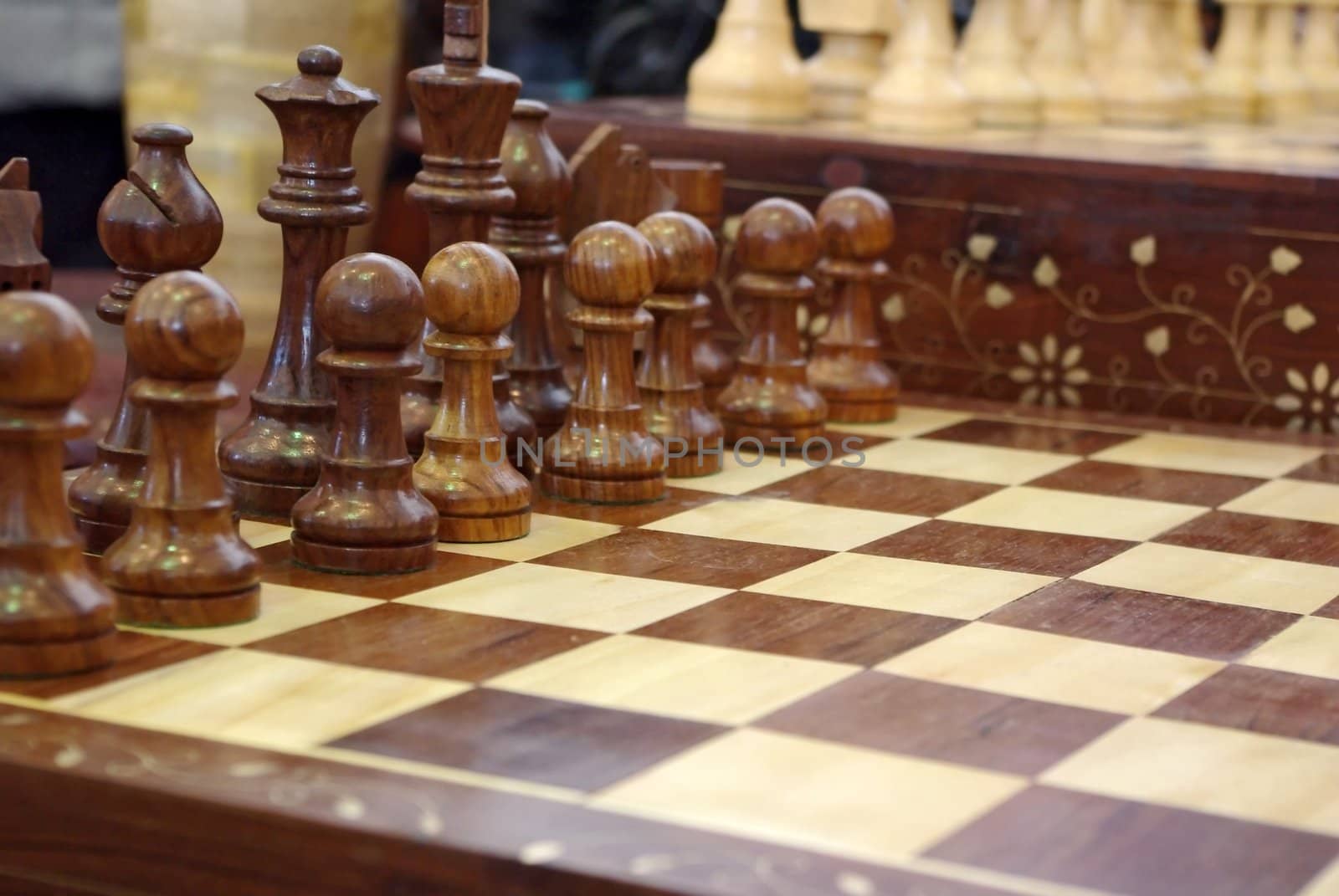 Chess pieces on wooden playboard by Vitamin