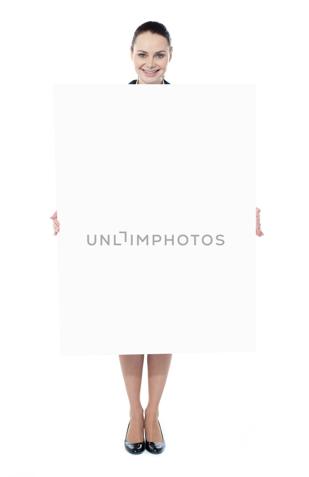 Young woman holding blank billboard by stockyimages