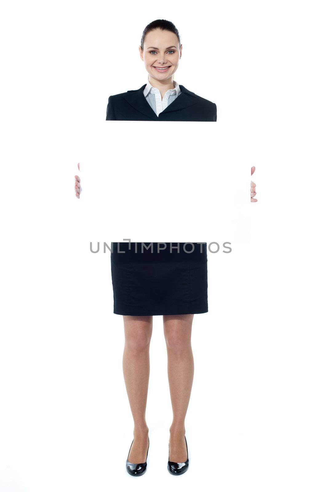 Caucasian businesswoman holding a blank billboard by stockyimages