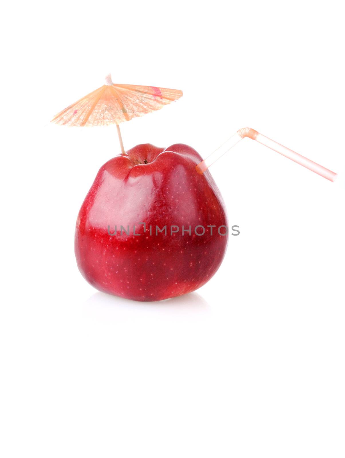 Red apple with cocktail tube and umbrella