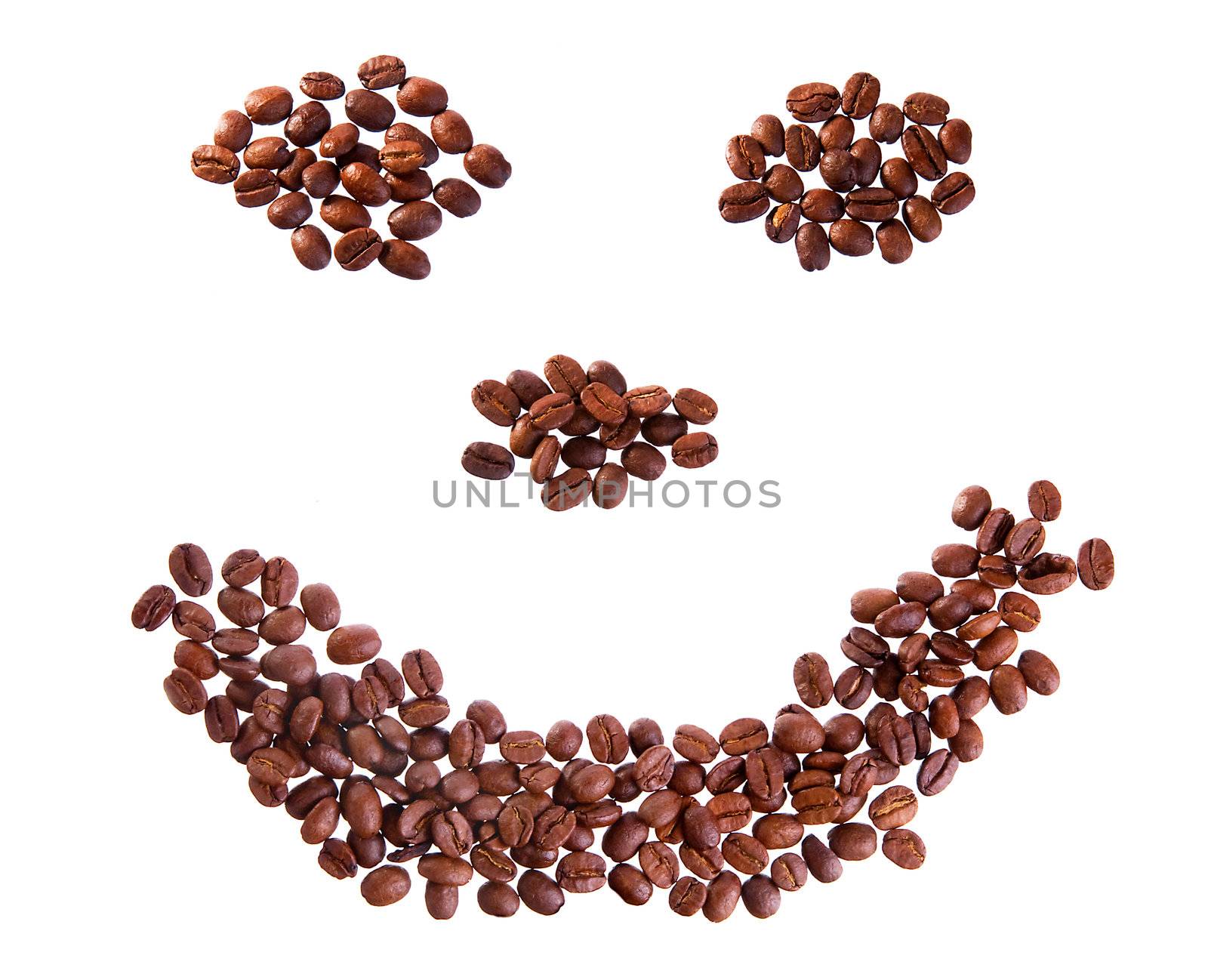 Roasted coffee beans placed in shape of smile on a white background
