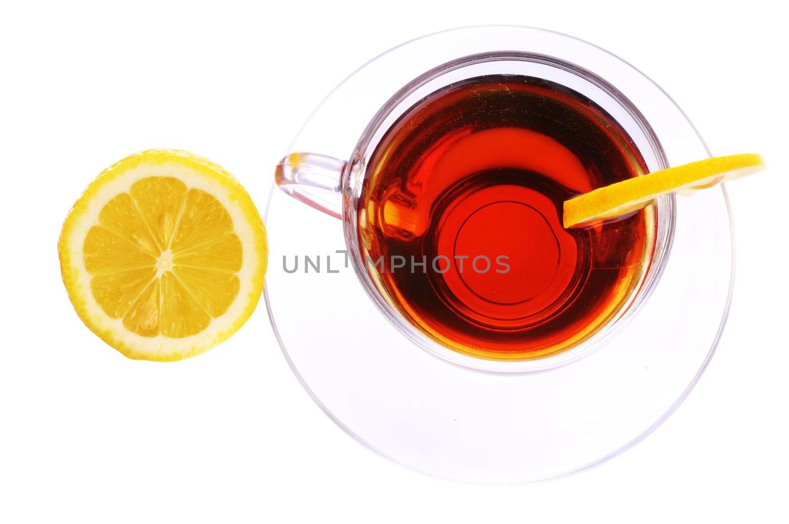 Transparent cup with black tea and a lemon isolated