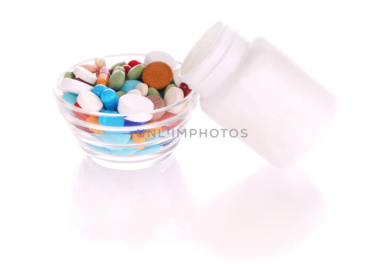 Transparent saucer and white bottle with many-colored pills