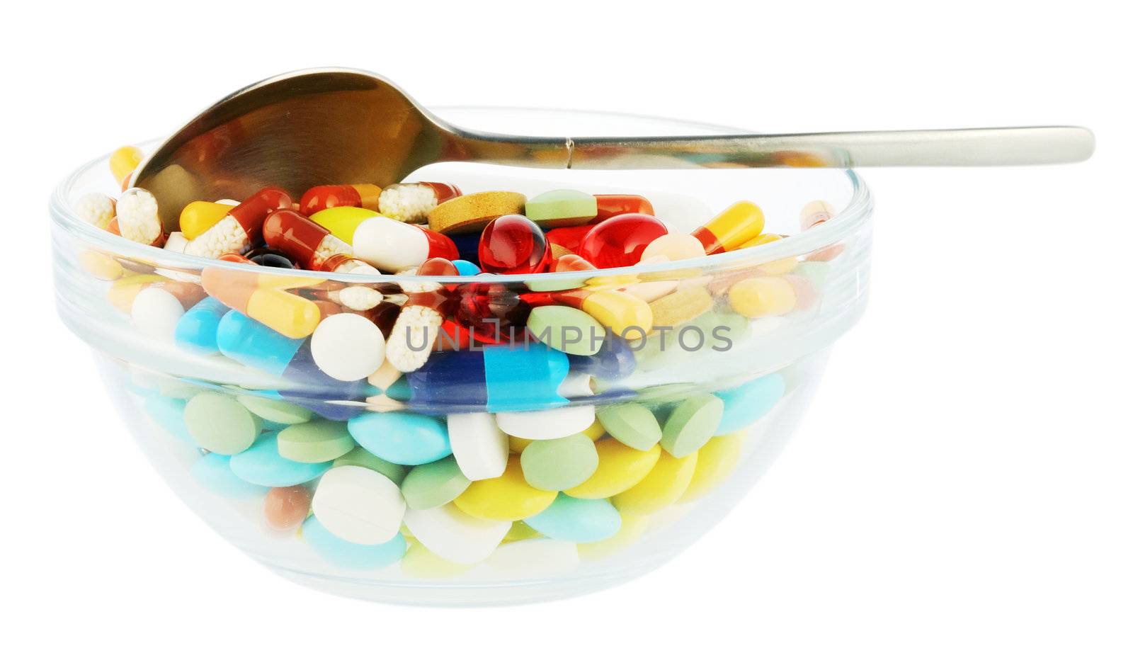 Transparent saucer with many-colored pills ans spoon