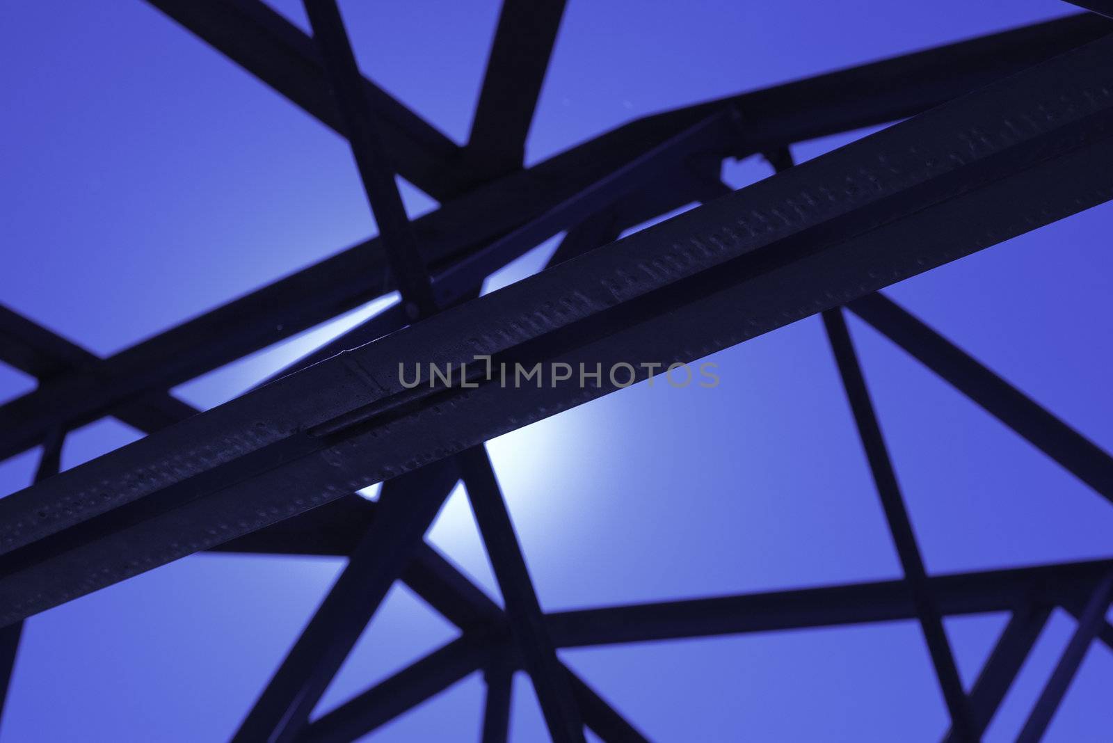 industrial building with black steel strusses and bright light behind trusses