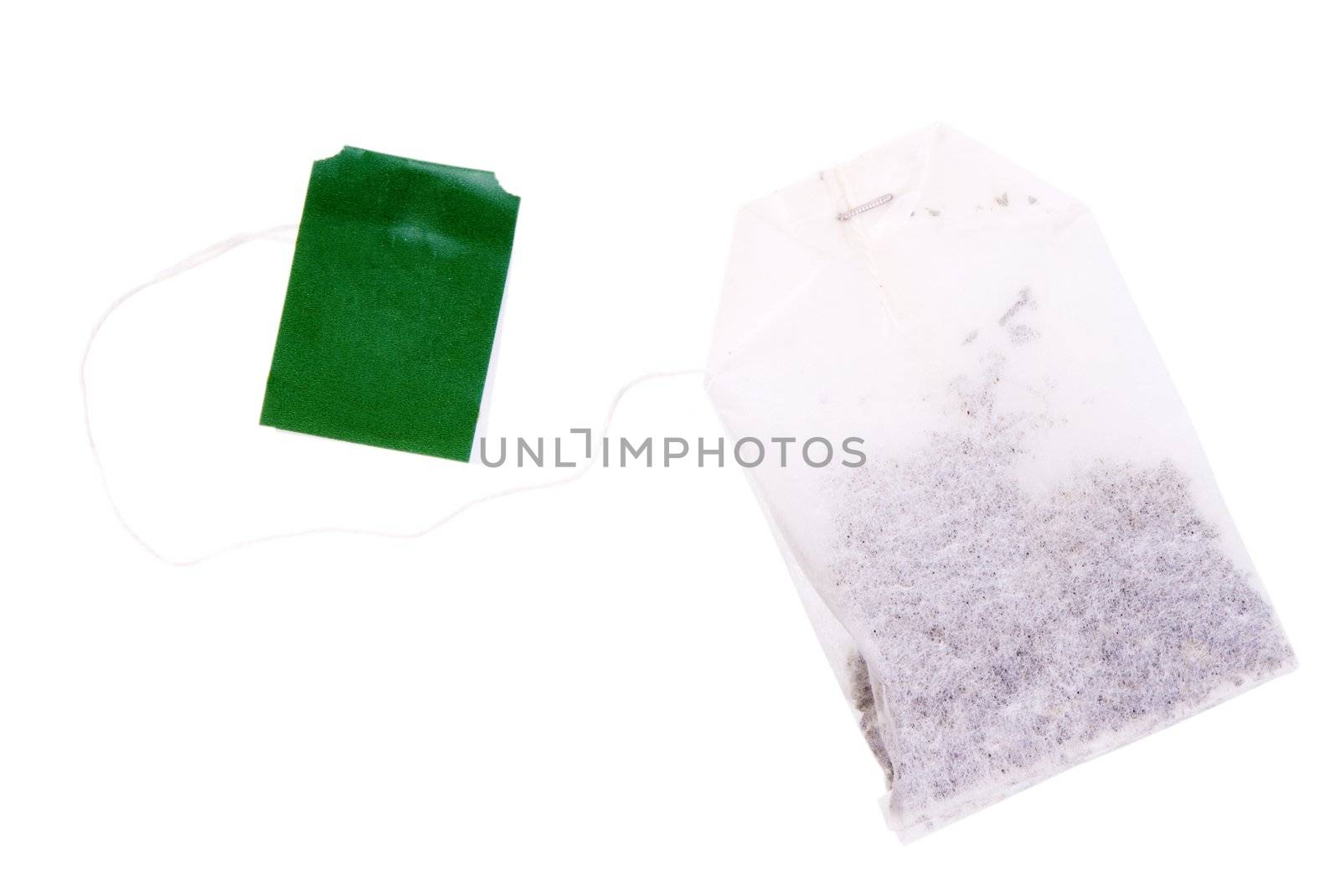One teabag with black tea and green label isolated on white background