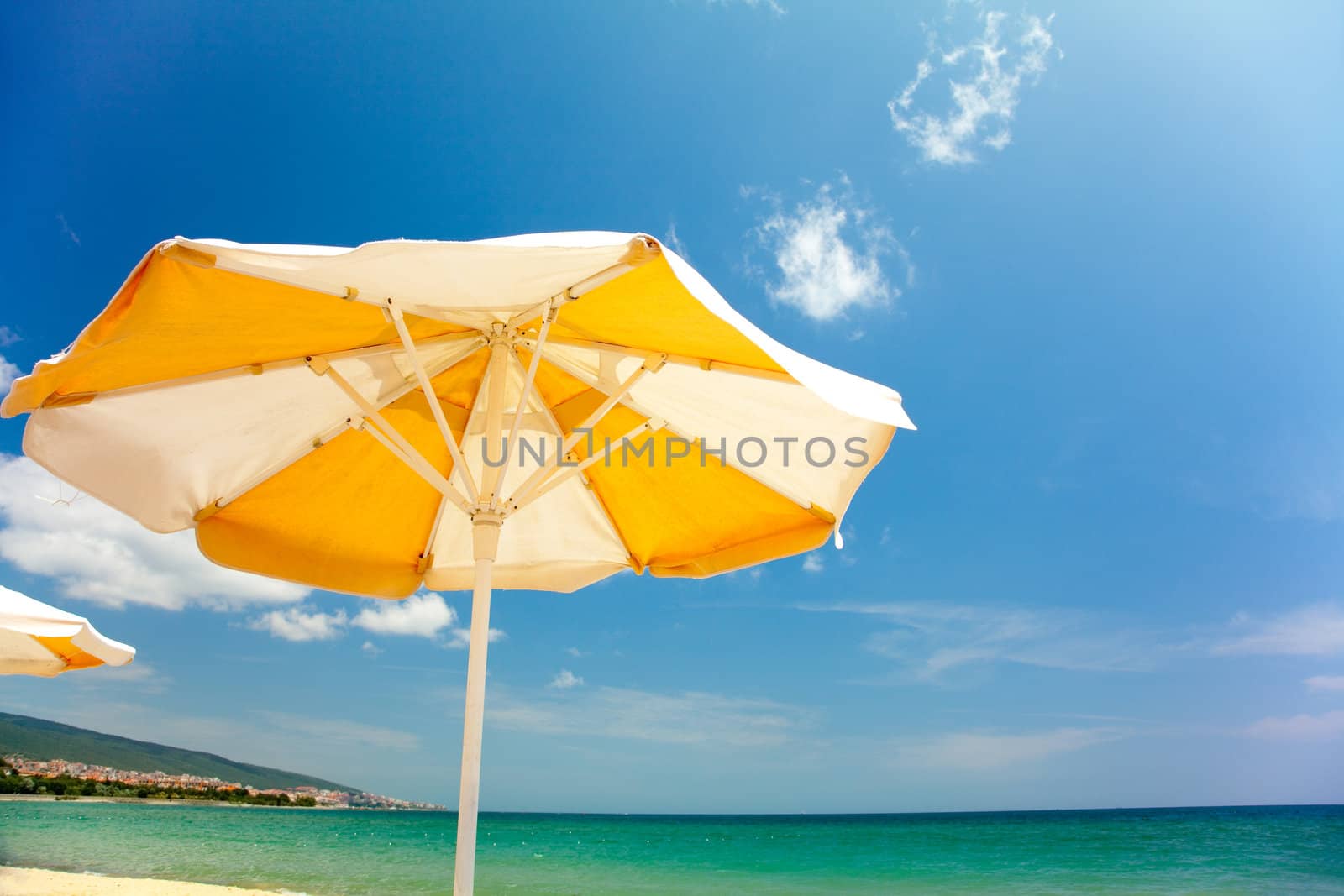 Orange umbrella on beautiful tropic beach 