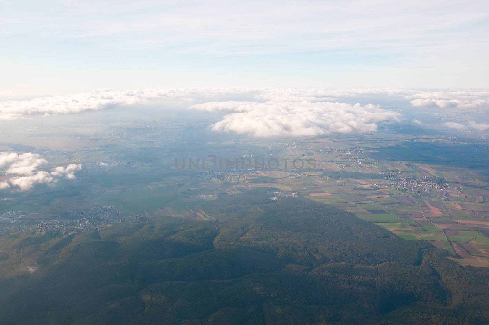 Beautiful view above cloudscape and fields by iryna_rasko