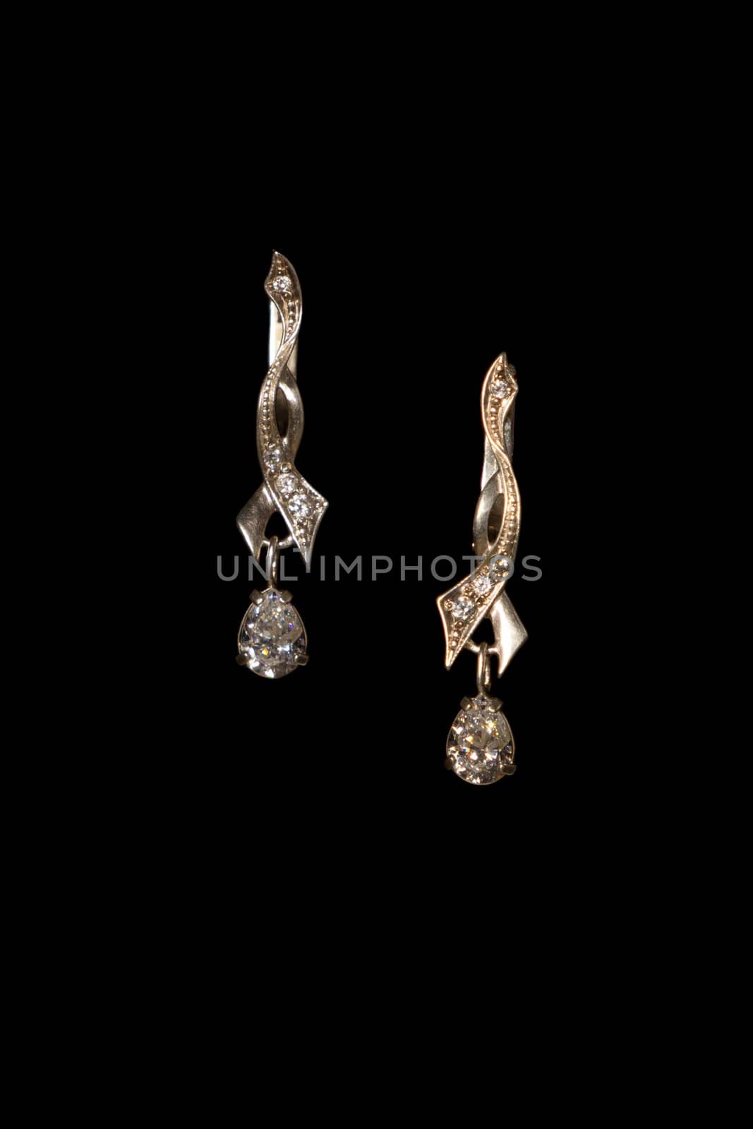 Shining elegant modern earrings with zircons isolated on black