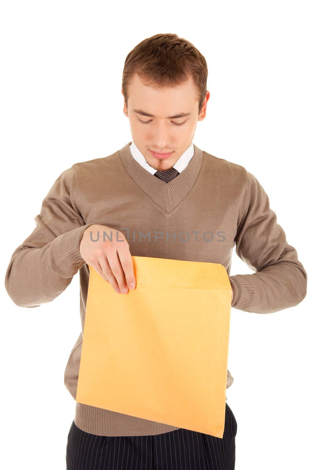 Young business man opens a yellow post package with interest. Isolated on white.