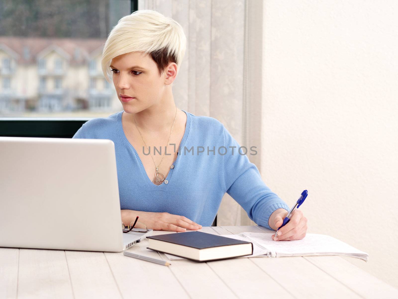 Photo of a successful young businesswoman with laptop computer in office.
