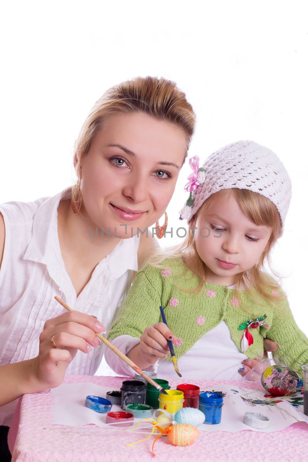 Mother and little daughter painting easter eggs isolated on white