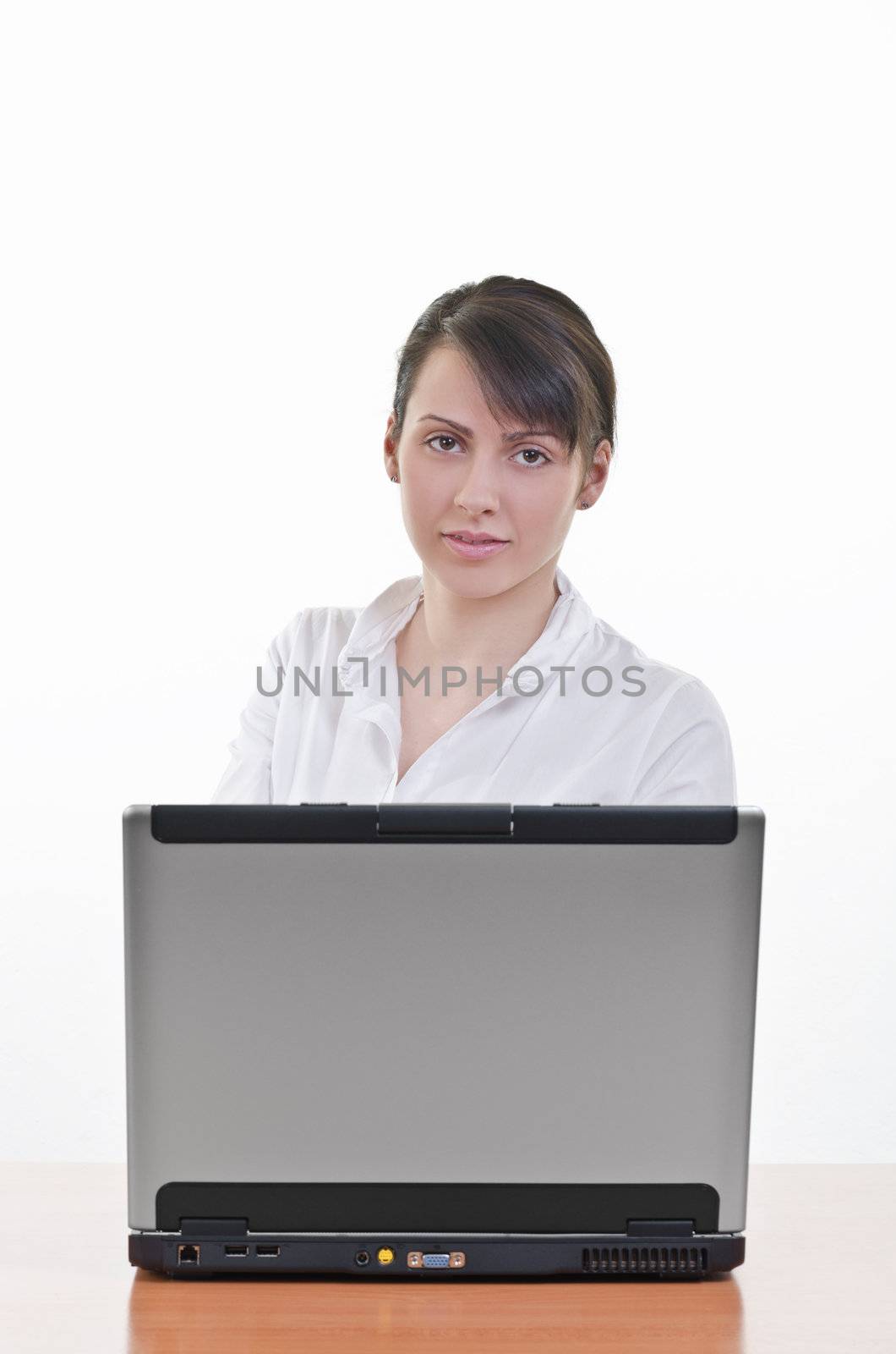 portrait of Pretty business woman at office desk in front of laptop, vertical shot, focus on eyes