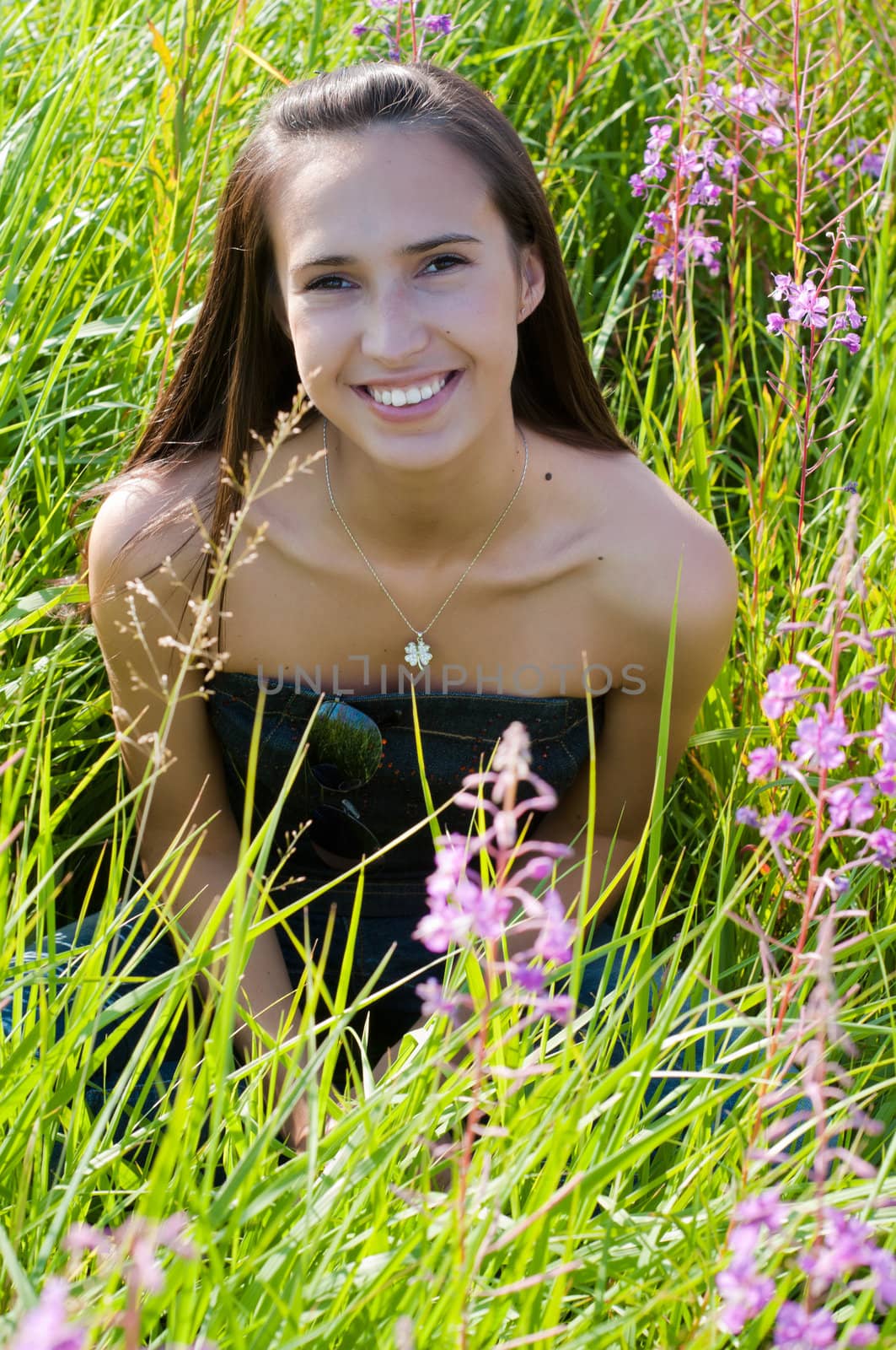 Beautiful brunette woman in grass by anytka