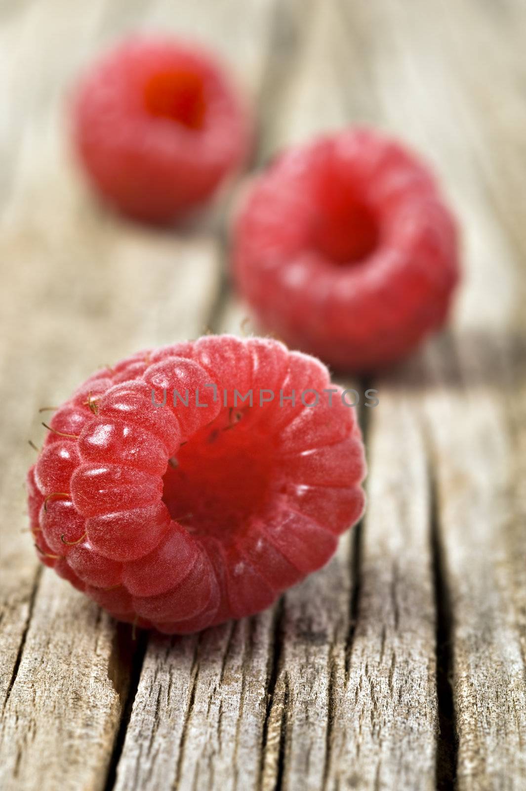 Fresh healthy organic raspberry on wooden background by tish1