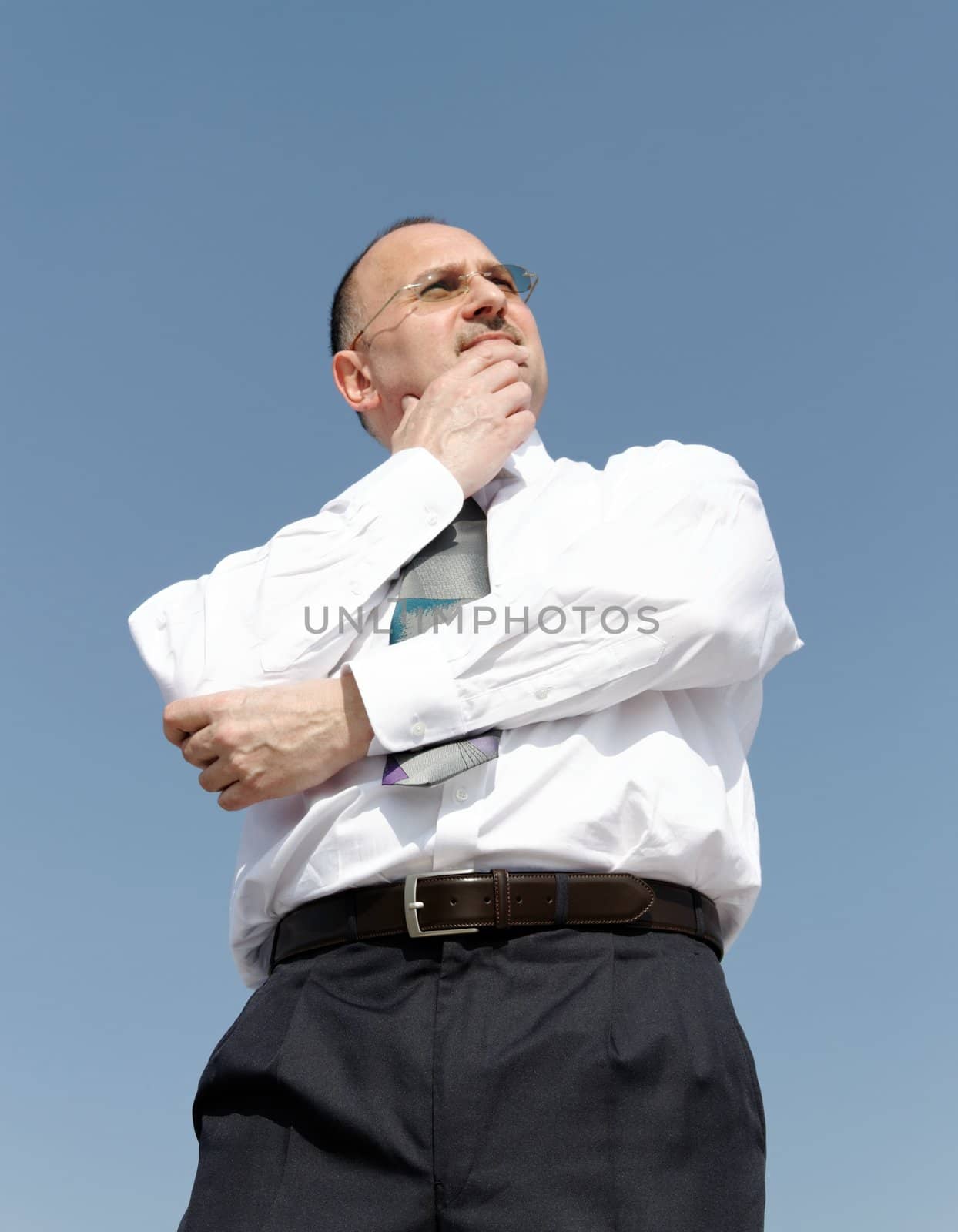 thoughtful businessman outdoors with blue background