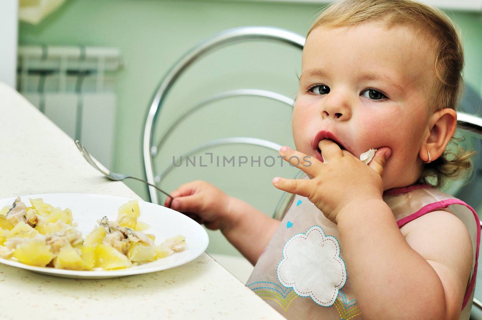 sweet baby girl eating on her own