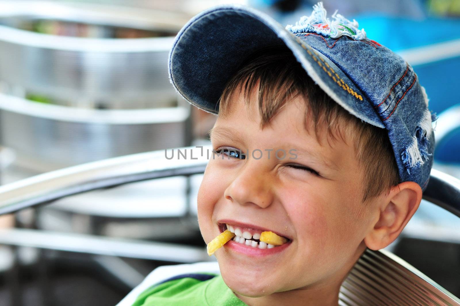 little boy enjoying french fries  in cafe