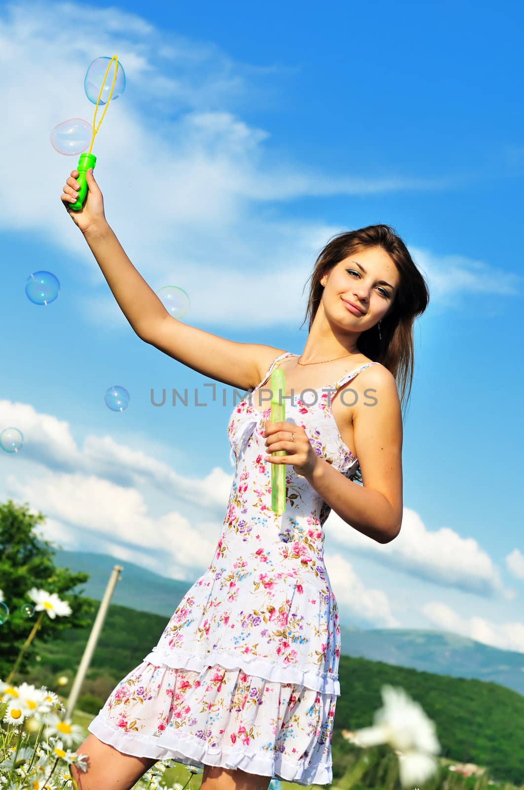 teen girl blowing soap bubbles by Reana