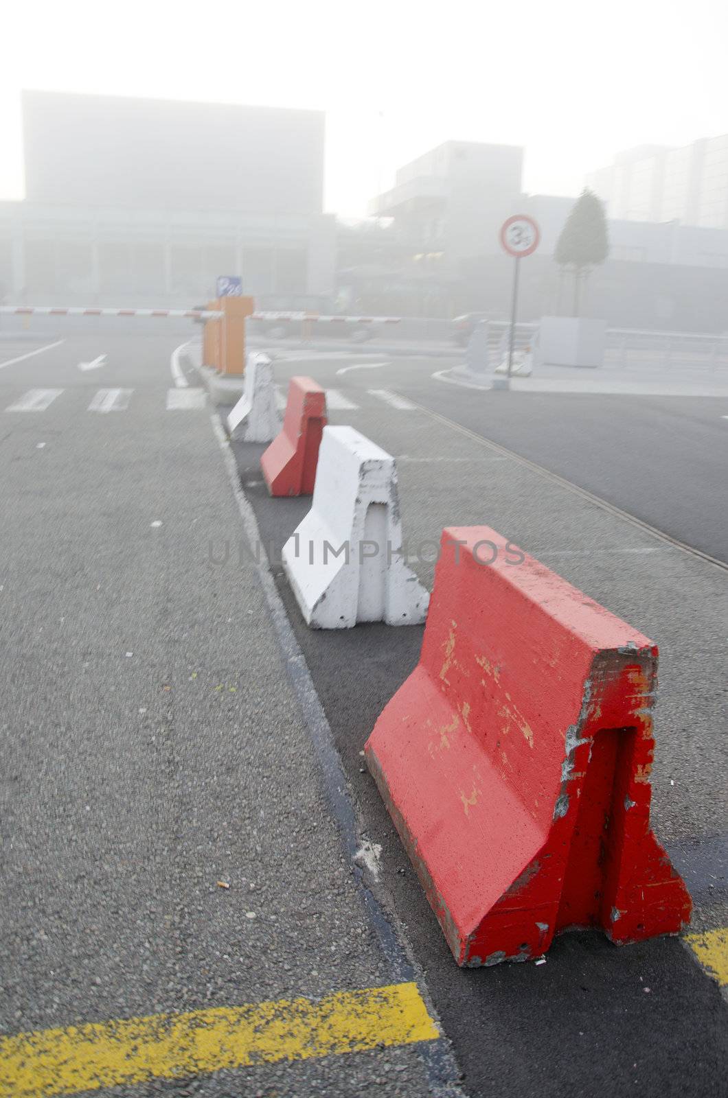 city in morning fog. concrete lower road barriers by sauletas