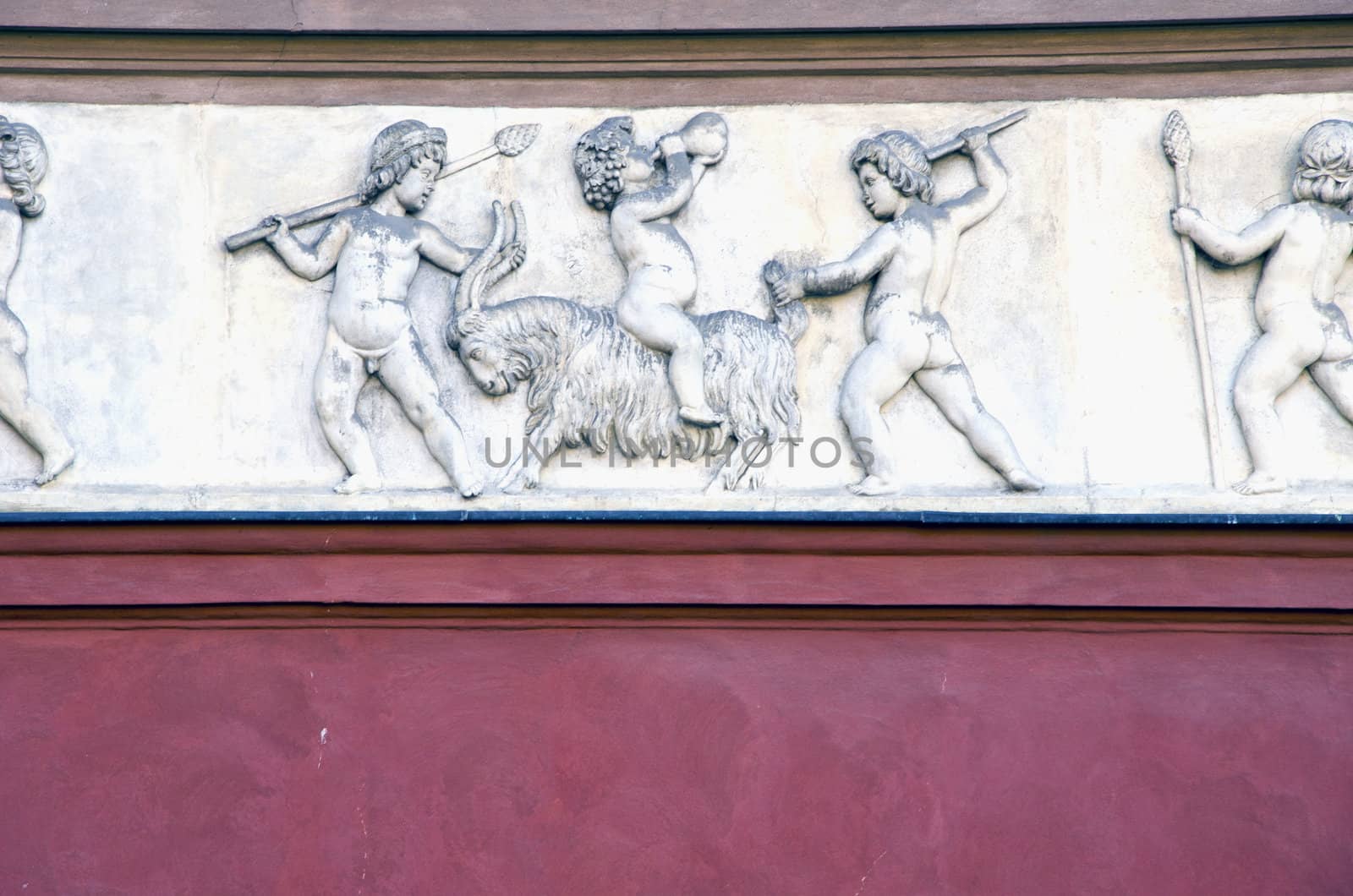 roman architectural retro vintage wall background. people shown in artwork hunting animal.