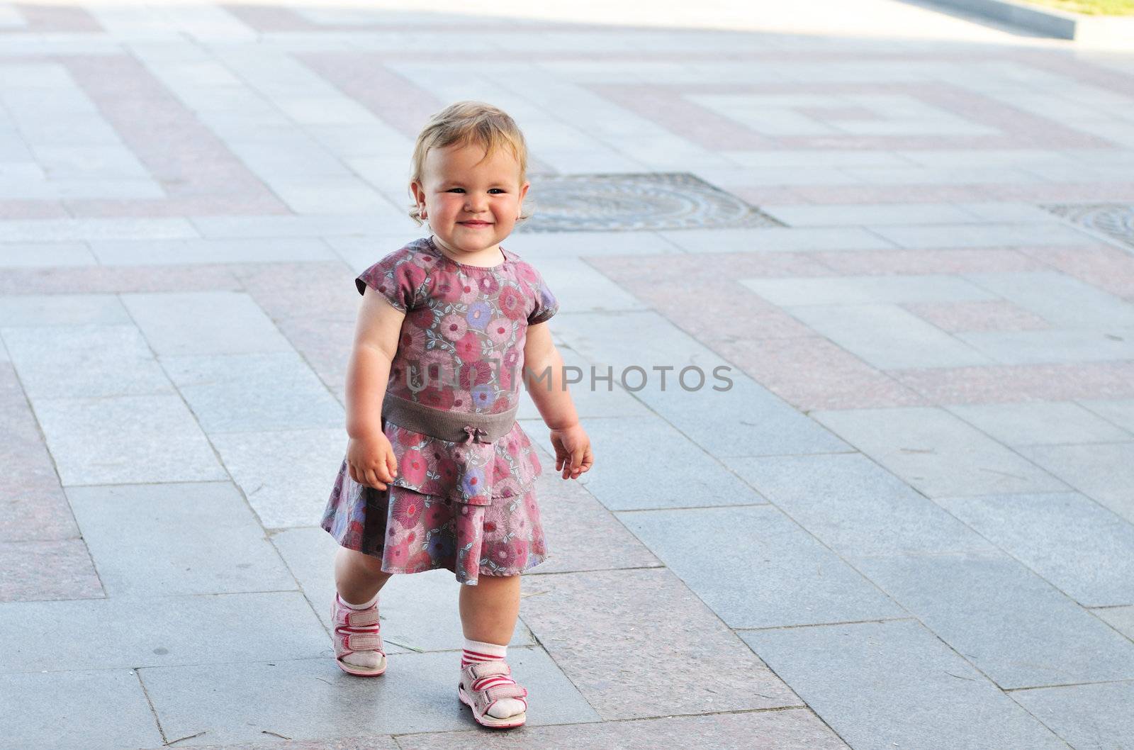 baby girl walking  by the street her first steps