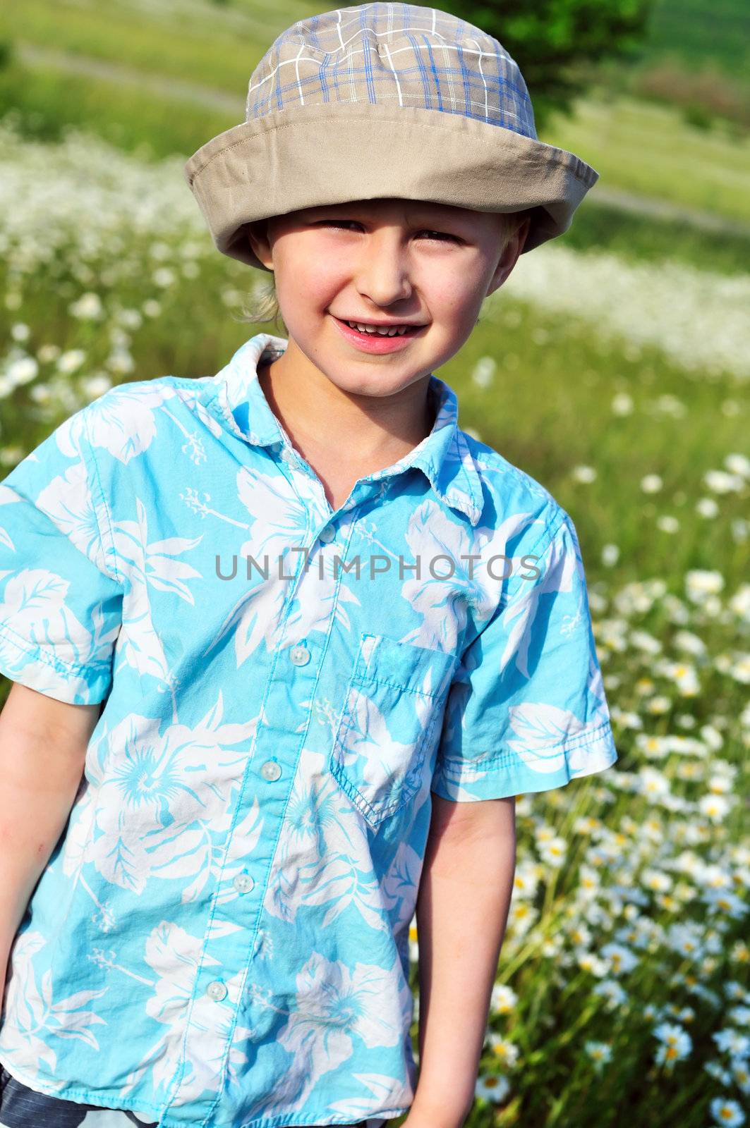 boy wearing  boonie hat  standing  in field