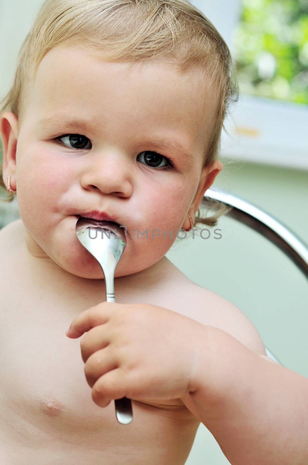 baby girl  with a spoon in her mouth