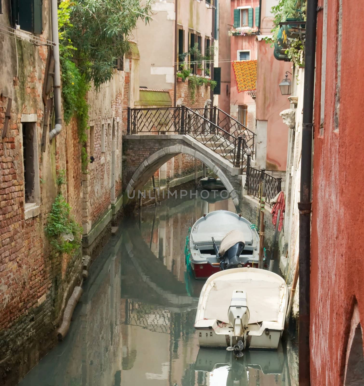 Canal, bridge, boats and reflections in Venice