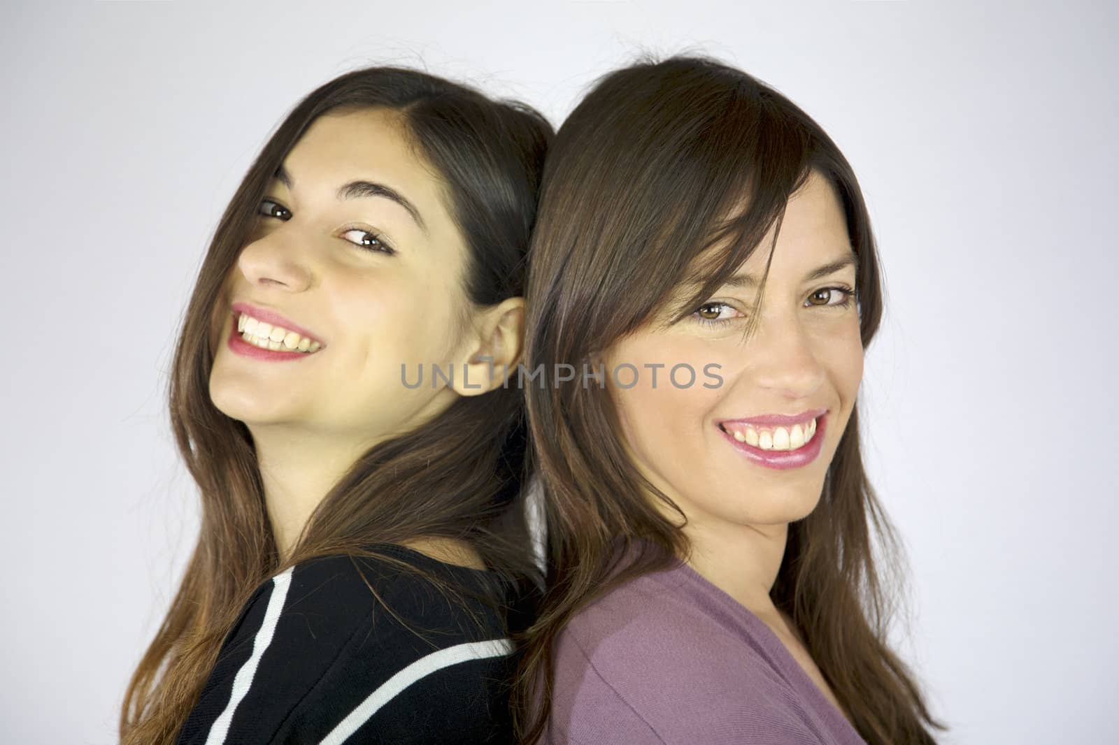 Two girlfriends happy laughing looking into camera